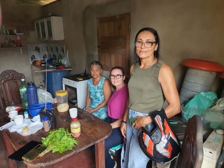 Mulheres numa cozinha, com alimentos e hortaliças sobre a mesa