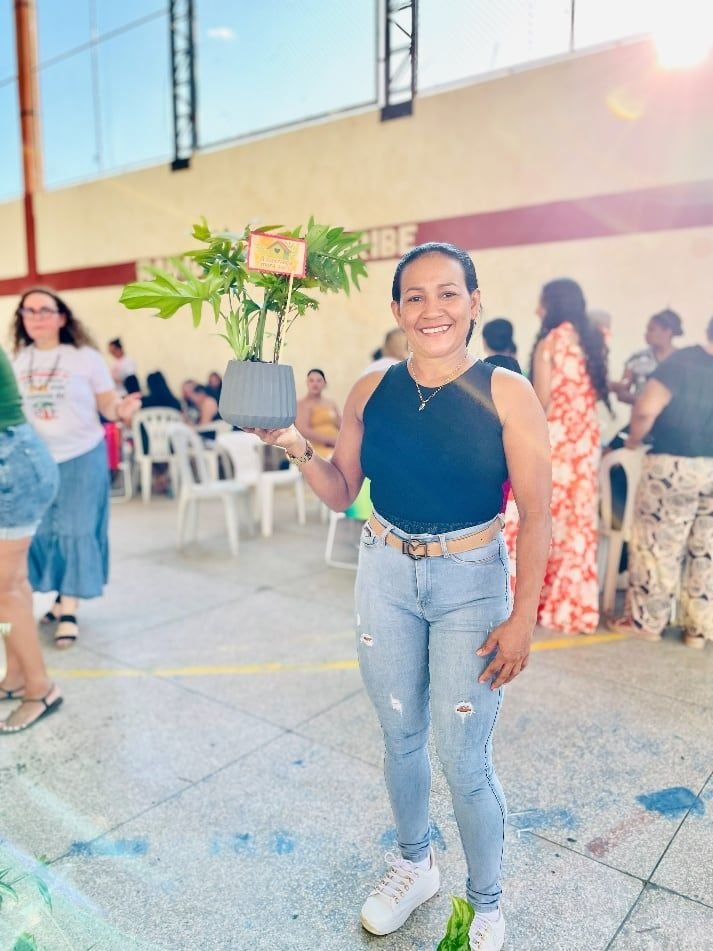 Mulher posando num pavilhão com participantes ao fundo