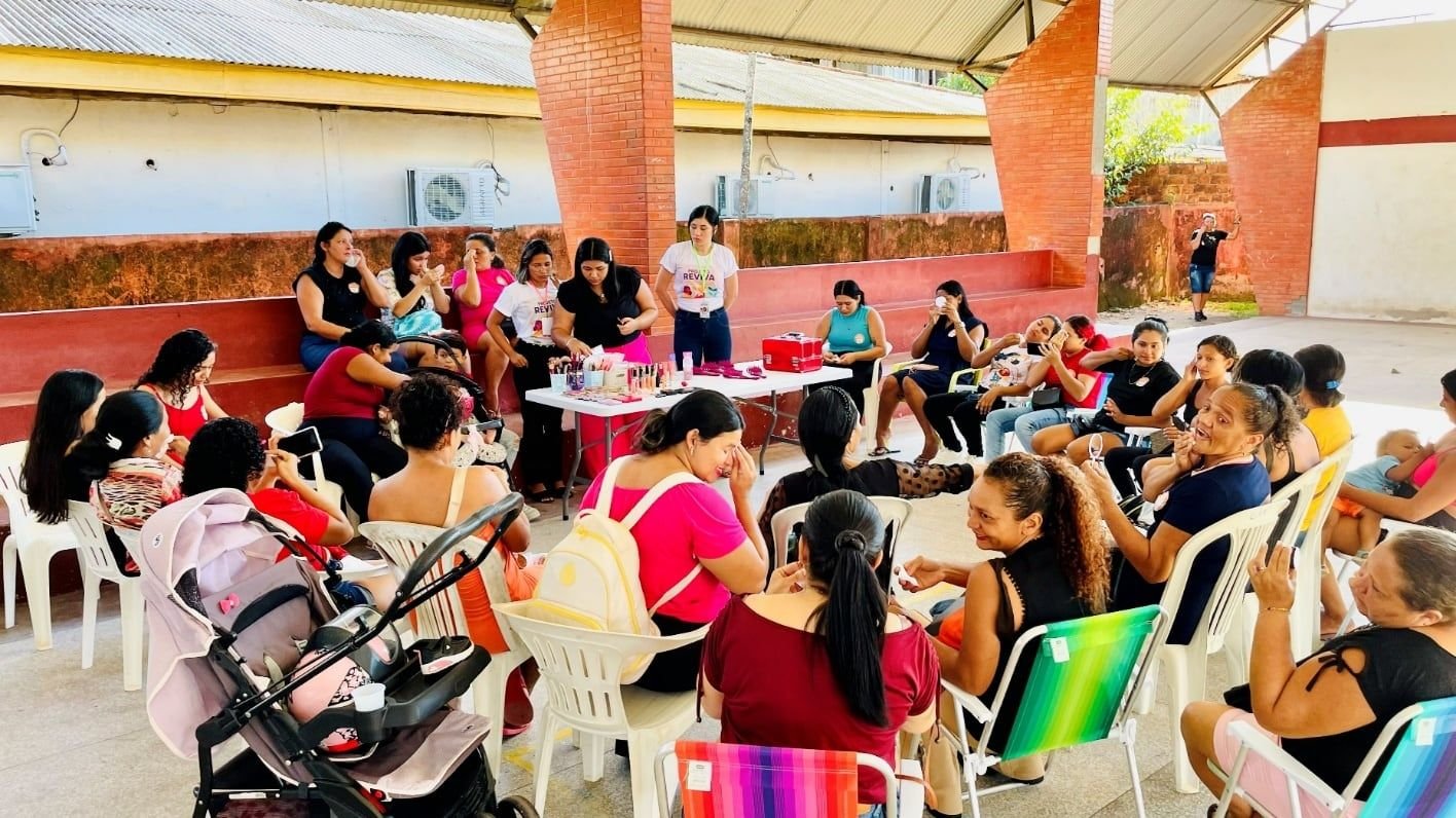 Mulheres sentadas em roda num pavilhão