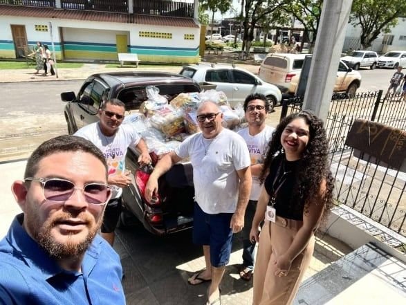 Grupo ao lado de uma caminhonete carregada de doações