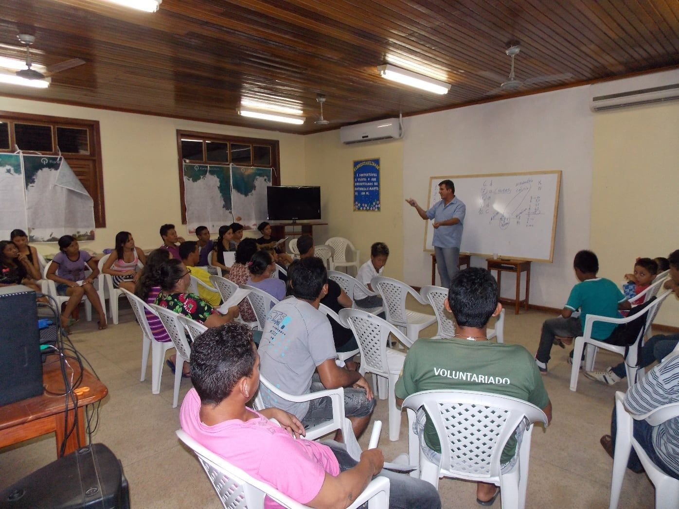 Participantes sentados numa sala de aula ouvindo um instrutor